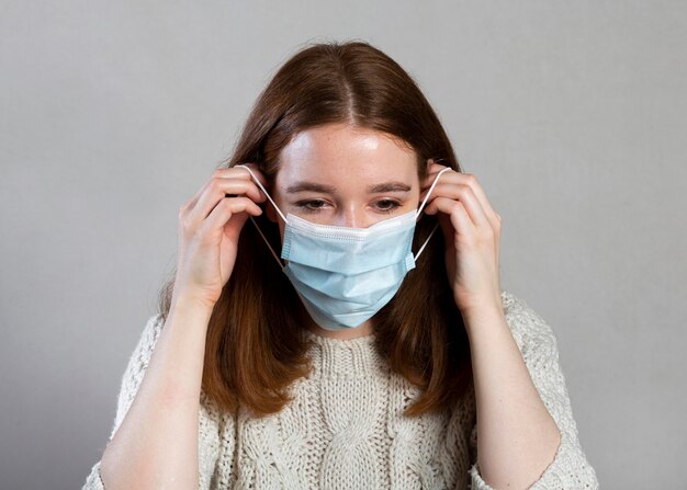 Front view of woman using a medical mask for protection