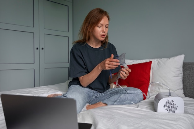 Front view woman using nebulizer at home