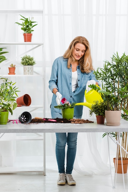 Free photo front view woman watering flower