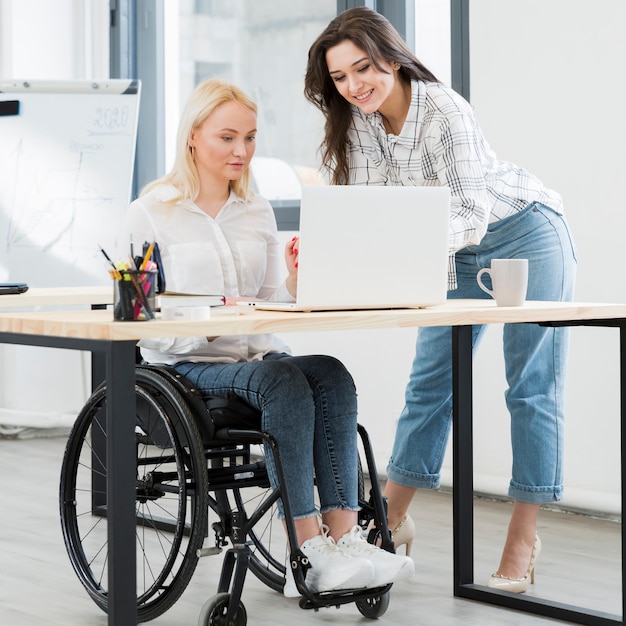 Front view of woman in wheelchair working at desk