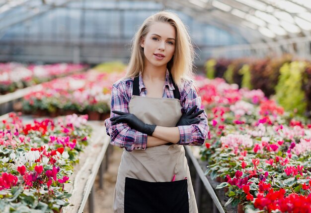 Front view woman with apron caring for flowers