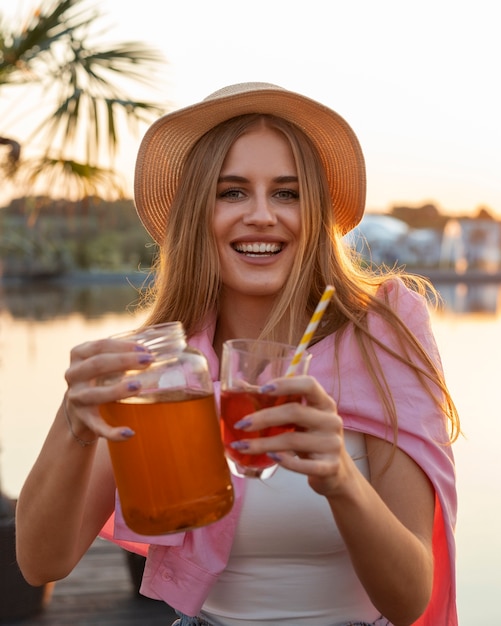 Free photo front view woman with delicious kombucha outdoors