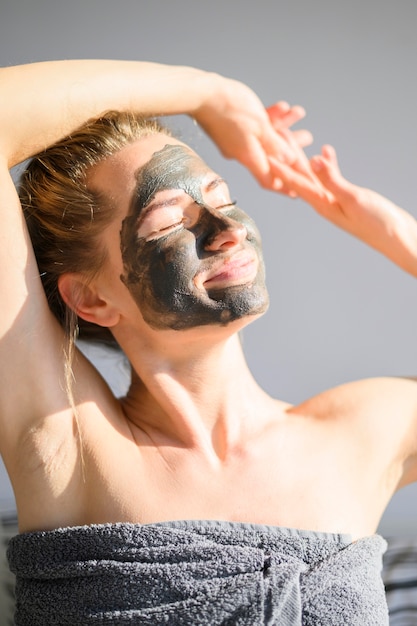 Front view of woman with face mask basking in the sun at home