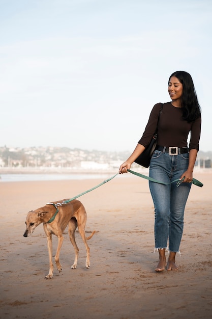 Front view woman with greyhound dog outdoors