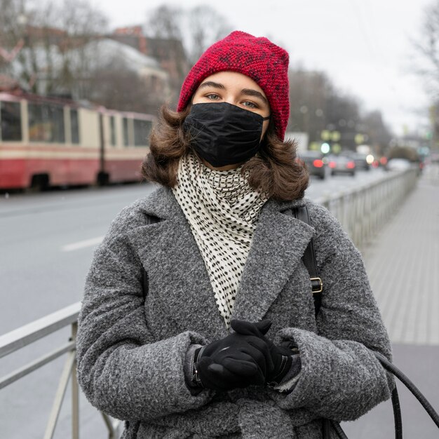 Front view of woman with medical mask outdoors in the city