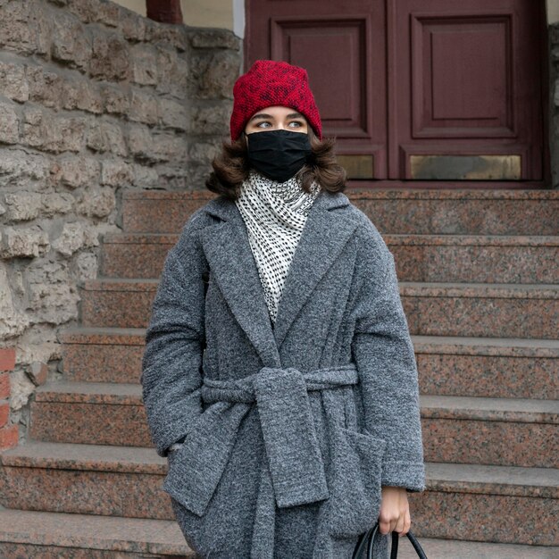 Front view of woman with medical mask outdoors