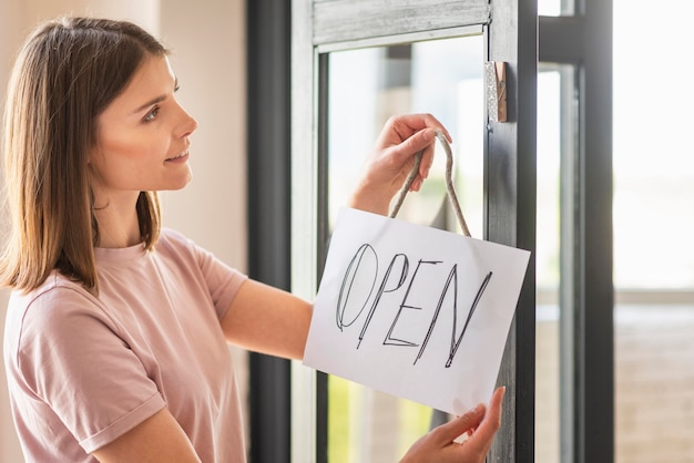 Free photo front view of woman with open sign