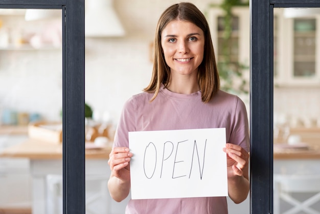 Free photo front view of woman with open sign