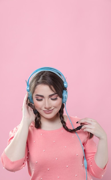 Free Photo front view of woman with ponytails listening to music on headphones