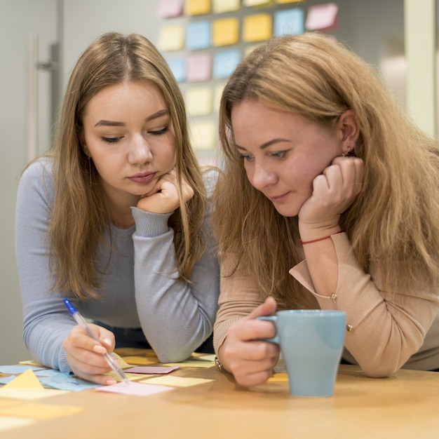 Front view of woman writing ideas on sticky notes at the office