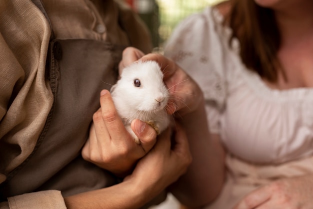 Free photo front view women holding bunnies