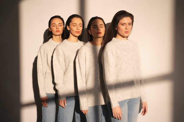 Front view of women in sweaters and jeans posing in window shadow