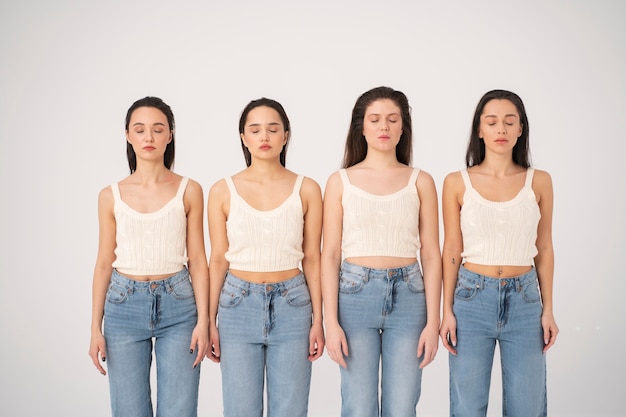 Free photo front view of women in tank tops and jeans posing in minimalist portraits