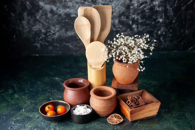 Free Photo front view wooden spoons with pots and cinnamon on dark table photo color seasoning salt cutlery