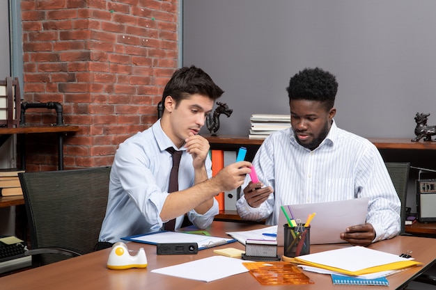 Front view work process two businessmen working in office