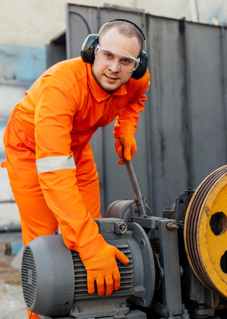 Front view of worker with headphones and protective glasses