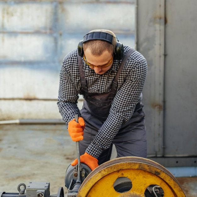 Free Photo front view of worker with protective gloves and headphones