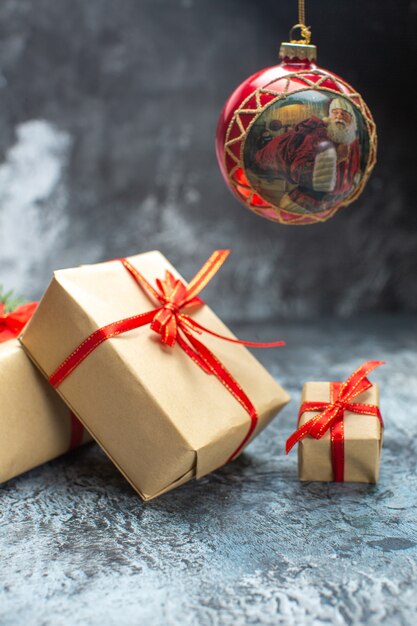 Front view xmas presents tied with red bows on a light-dark color photo new year holiday christmas gift