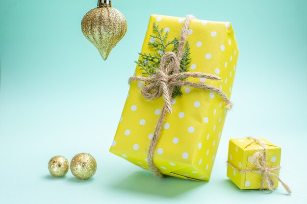 Front view of xsmas background with yellow gift boxes and decoration accessories on pastel green background