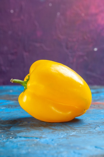 Free photo front view yellow bell-pepper on a blue-pink table