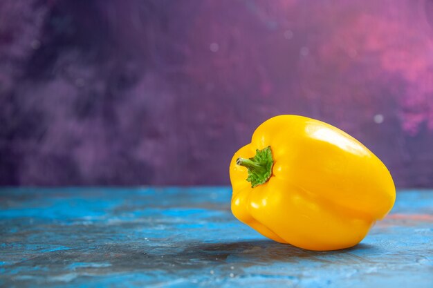 Front view yellow bell-pepper on blue-pink table