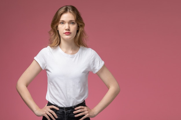 Front view young attractive female just posing in white t-shirt on the pink wall model color female young girl