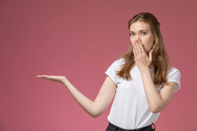 Front view young attractive female posing with shocked expression on the pink wall model color female young girl