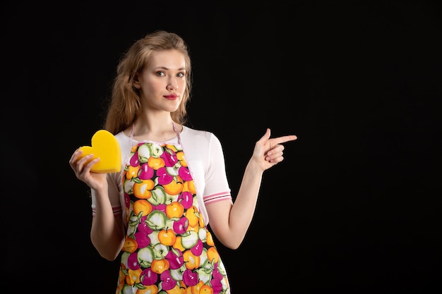 Free photo a front view young attractive girl in colorful cape holding yellow heart shape on the black background love smile positivity