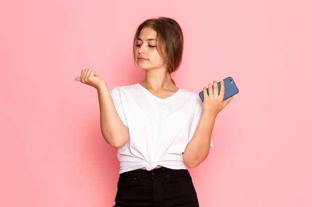 A front view young beautiful female in white shirt holding a phone