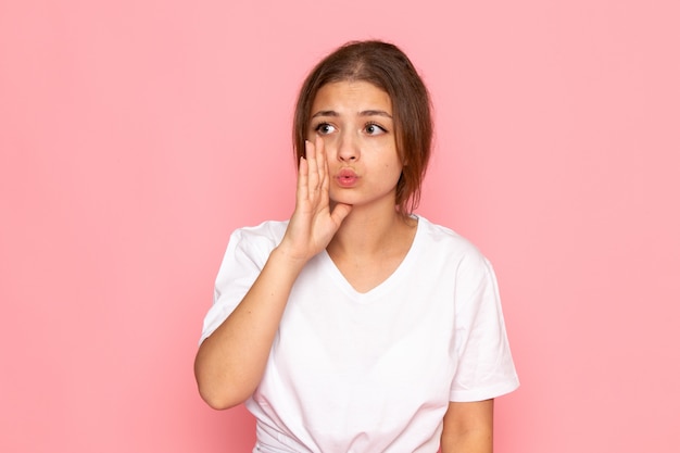 A front view young beautiful female in white shirt posing and whispering