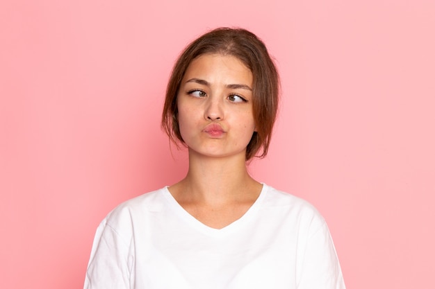 A front view young beautiful female in white shirt posing with funny expression