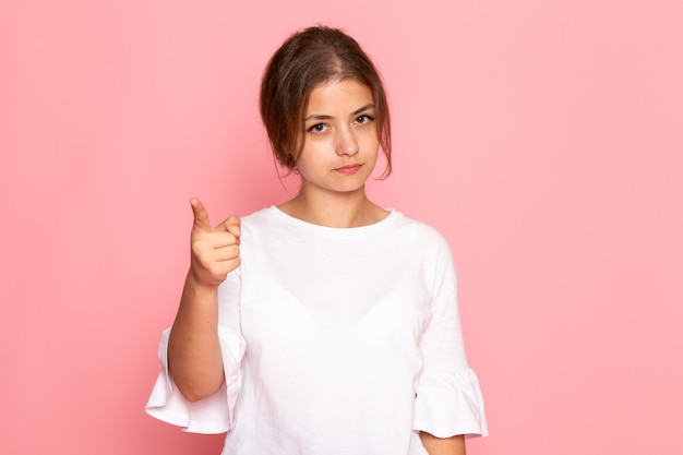 A front view young beautiful female in white shirt posing with warning expression