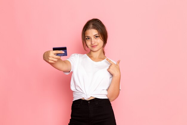 A front view young beautiful female in white shirt with holding purple card