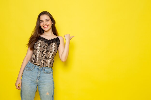 A front view young beautiful lady in brown blouse and blue jeans smiling