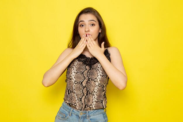 A front view young beautiful lady in brown blouse and blue jeans surprised