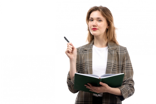 A front view young beautiful lady in white t-shirt black jeans and coat holding green book on the white