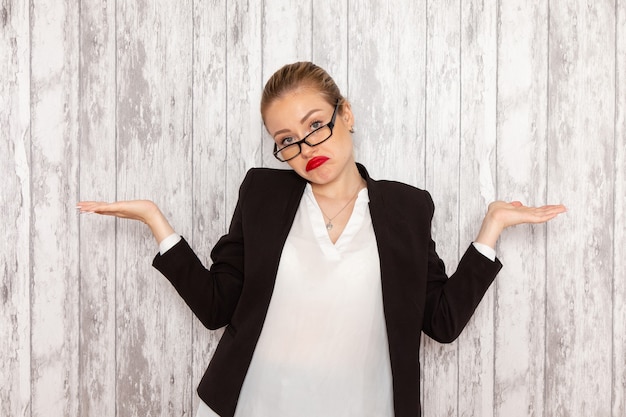 Front view young businesswoman in strict clothes black jacket with optical sunglasses posing on white wall job office business woman lady