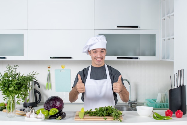 Front view young chef in uniform giving thumbs up