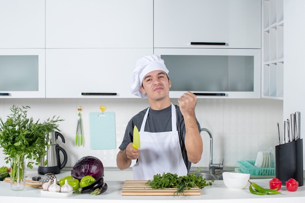 Front view young chef in uniform showing his happiness