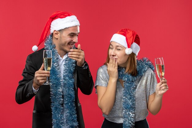 Front view young couple celebrating new year on red desk love christmas party drink