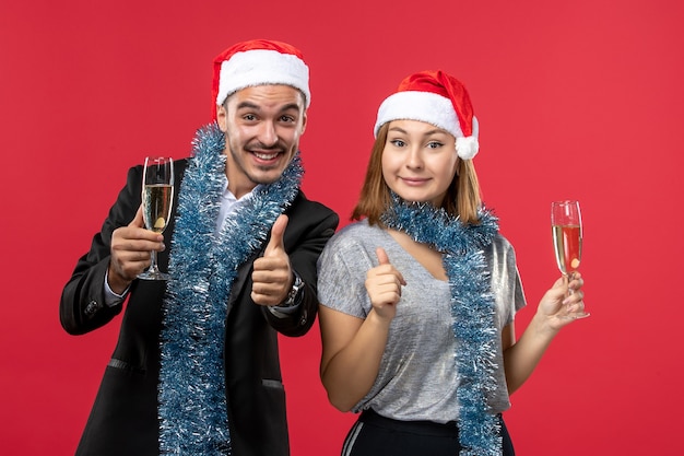 Free photo front view young couple celebrating new year on red floor love christmas party drink