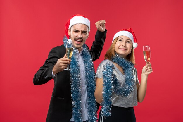 Front view young couple celebrating new year on red floor party christmas love