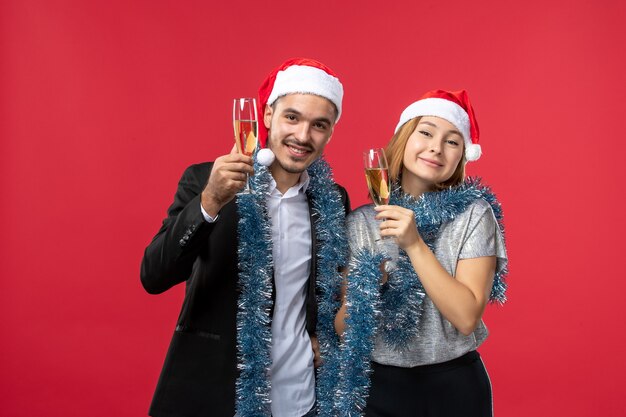 Free photo front view young couple celebrating new year on red floor party love christmas