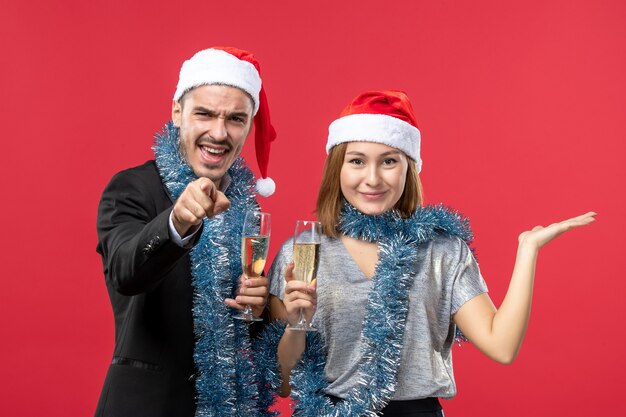 Front view young couple celebrating new year on red wall christmas love party