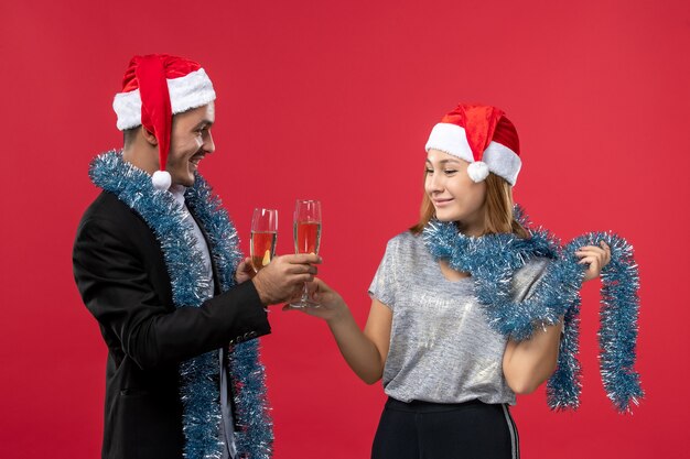 Front view young couple celebrating new year on red wall color love christmas