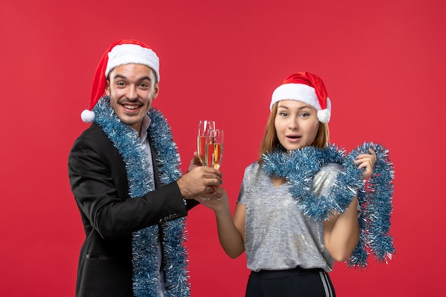 Front view young couple celebrating new year on the red wall color love christmas