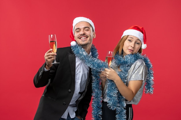 Front view young couple celebrating new year on a red wall love christmas color