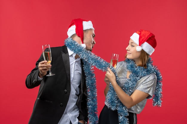 Free Photo front view young couple celebrating new year on red wall love christmas color