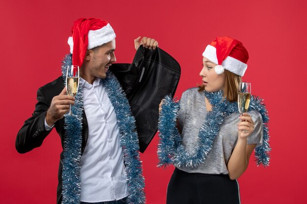 Free photo front view young couple celebrating new year on the red wall love christmas party