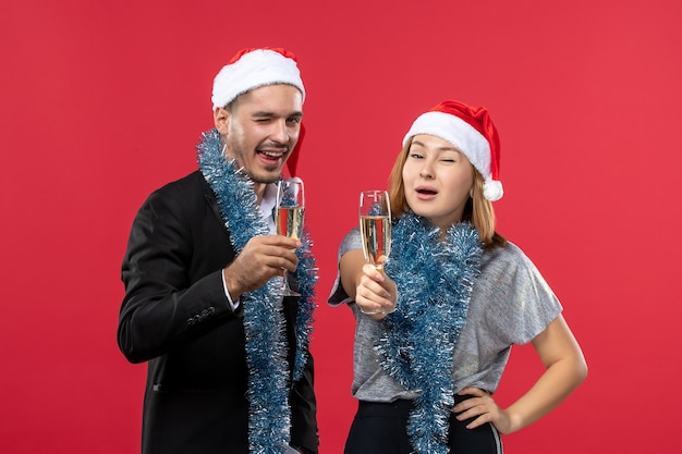 Front view young couple just celebrating new year on a red wall christmas love party